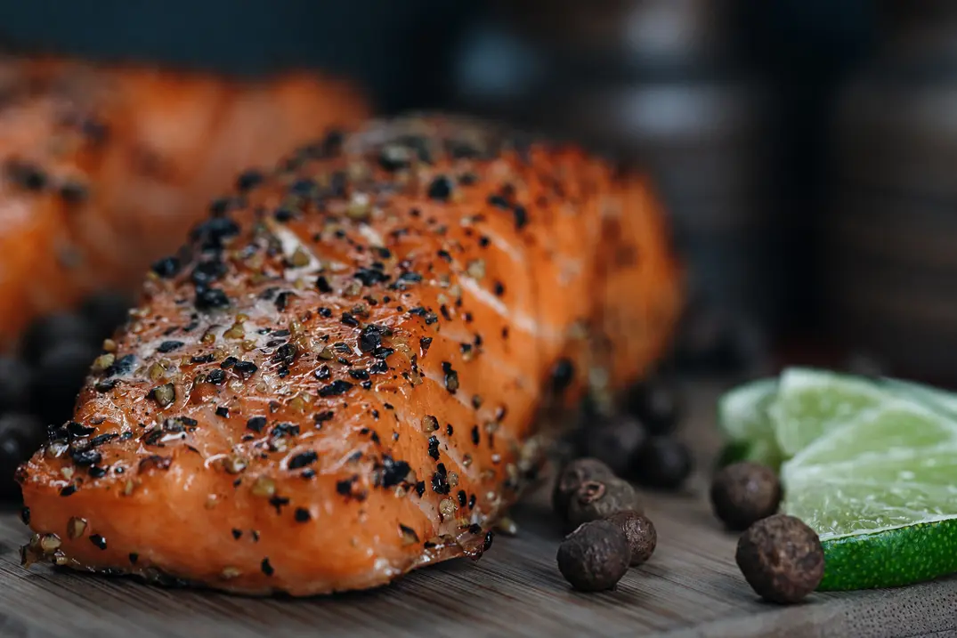 Pepper-crusted salmon with fresh lime slices