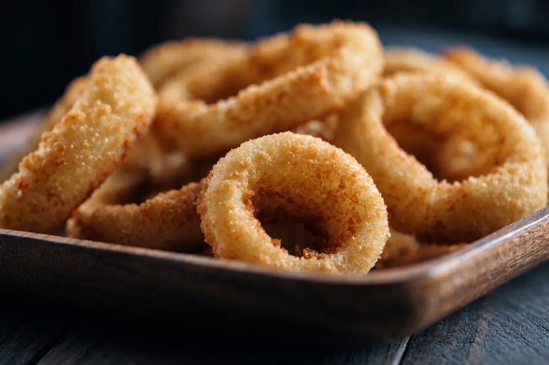 Golden fried rings served in a dark bowl