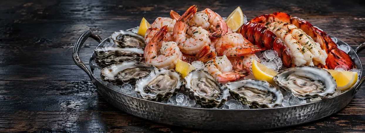 Oysters, shrimp, and lobster arranged on a seafood platter
