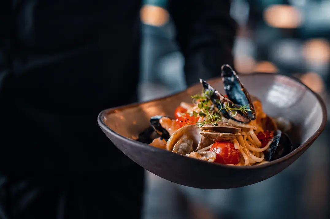 A bowl of seafood pasta with mussels, clams and tomatoes
